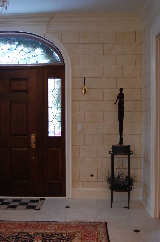 Photo of a mid-sized traditional foyer in Chicago with beige walls, ceramic floors, a single front door, a dark wood front door and beige floor.
