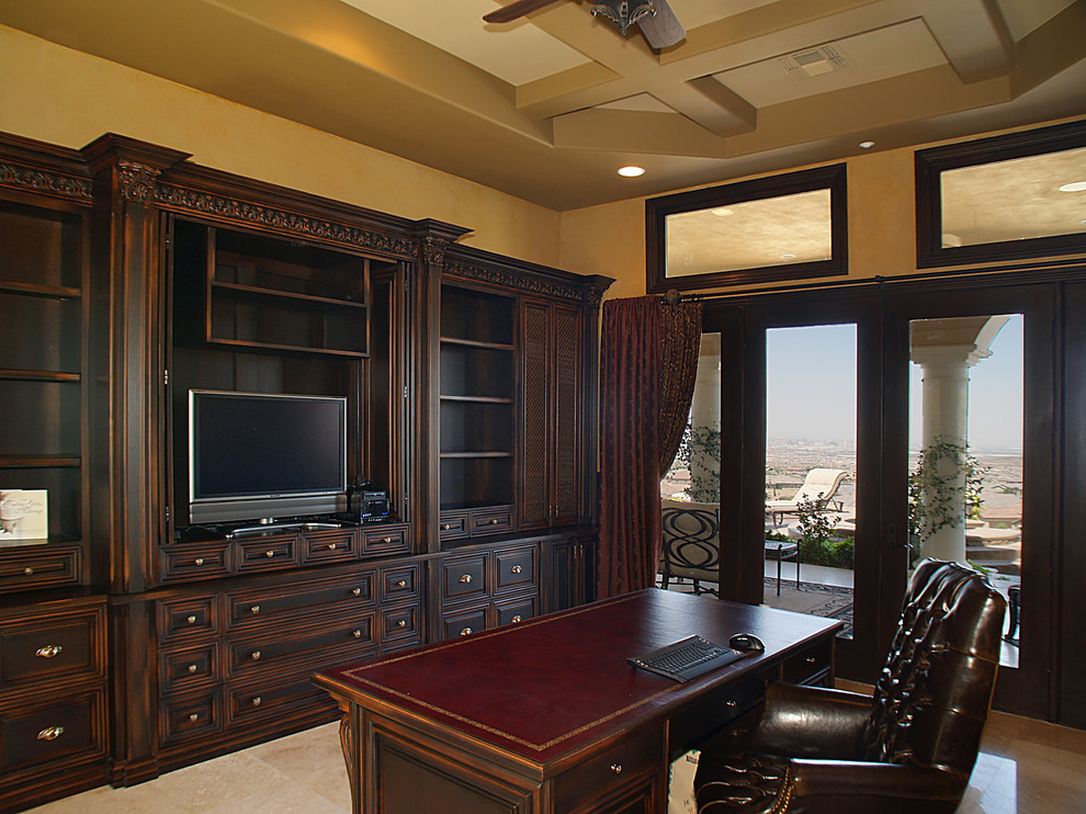 This is an example of an expansive mediterranean study room in Las Vegas with beige walls, brick floors, a freestanding desk, beige floor and vaulted.