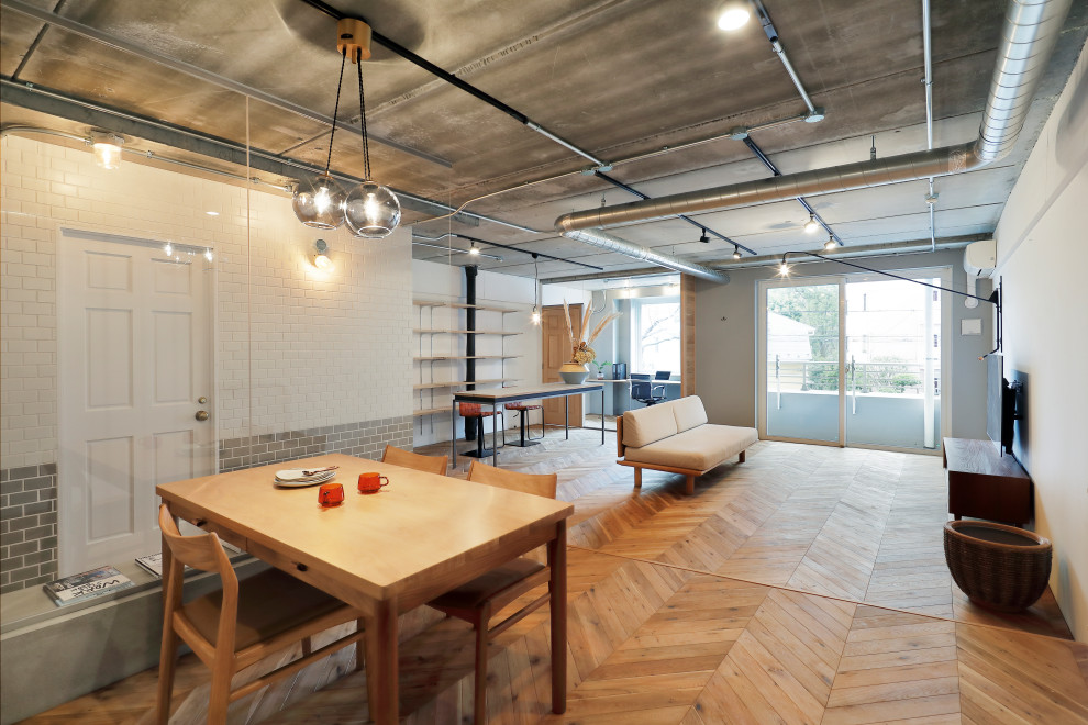 Contemporary open concept living room in Tokyo with white walls, medium hardwood floors, no fireplace and a wall-mounted tv.
