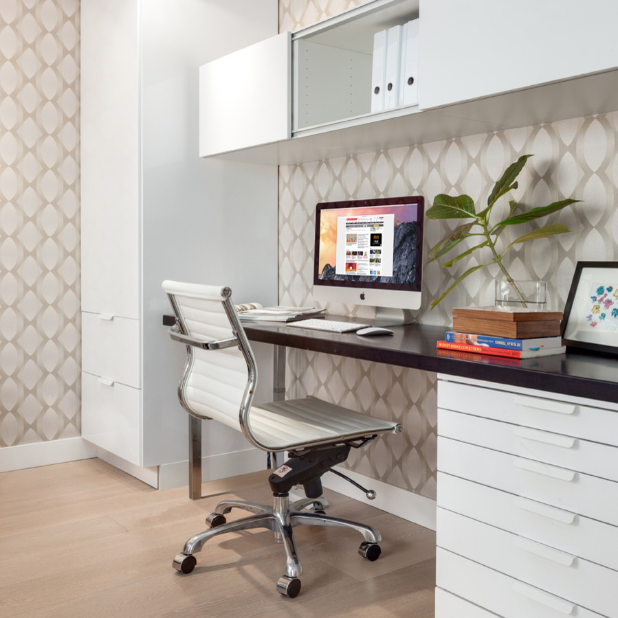 This is an example of a mid-sized transitional home studio in Vancouver with light hardwood floors and a freestanding desk.