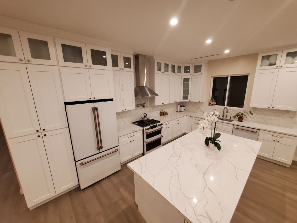 Design ideas for a mid-sized contemporary l-shaped eat-in kitchen in Los Angeles with shaker cabinets, quartz benchtops, engineered quartz splashback and with island.
