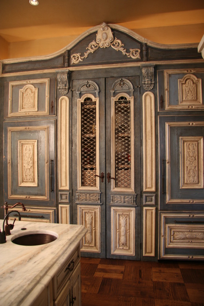 Large mediterranean single-wall eat-in kitchen in Oklahoma City with raised-panel cabinets, distressed cabinets, marble benchtops, subway tile splashback, black appliances, dark hardwood floors, with island and an undermount sink.