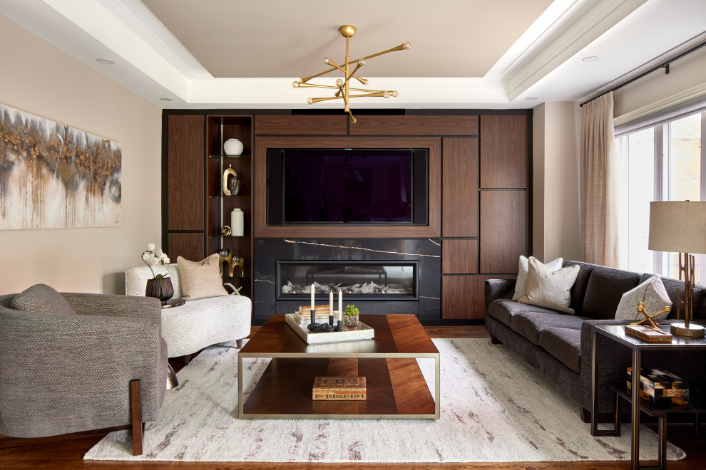 Inspiration for a mid-sized contemporary formal and enclosed medium tone wood floor, brown floor and tray ceiling living room remodel in Toronto with beige walls, a standard fireplace, a media wall and a tile fireplace