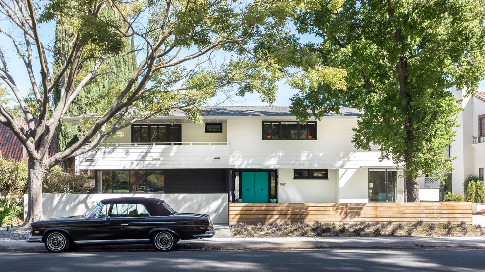 Midcentury two-storey white house exterior in Sacramento with a hip roof and a shingle roof.