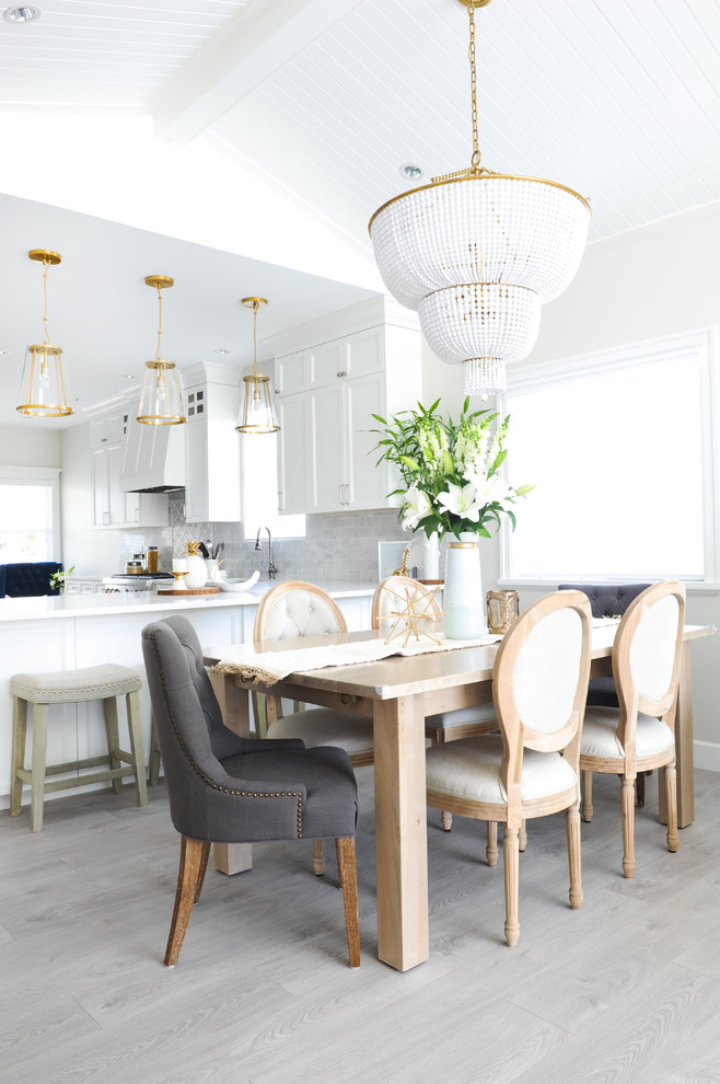 Design ideas for a transitional dining room in Vancouver with white walls, laminate floors and grey floor.