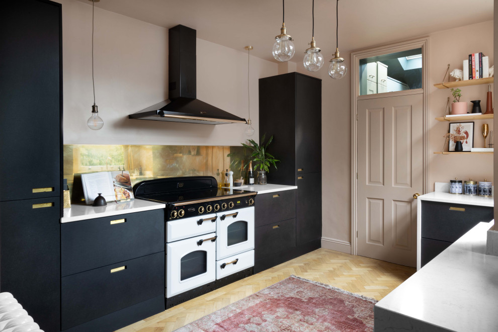 This is an example of a medium sized midcentury galley kitchen/diner in Manchester with a belfast sink, flat-panel cabinets, black cabinets, quartz worktops, metallic splashback, metal splashback, integrated appliances, light hardwood flooring, no island and white worktops.