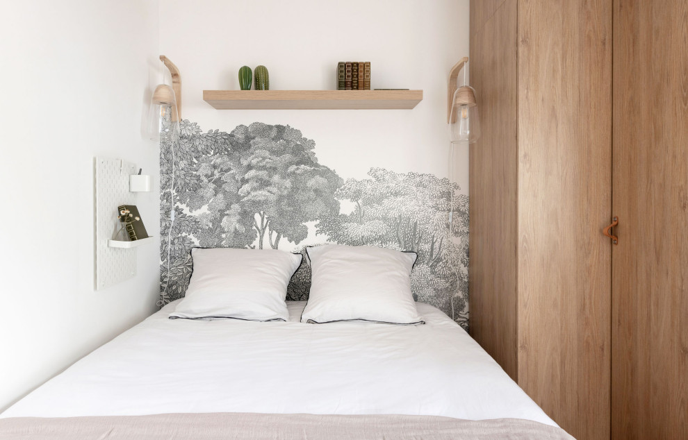 This is an example of a small scandinavian gender neutral teen’s room in Lyon with white walls, light hardwood flooring, beige floors and wallpapered walls.