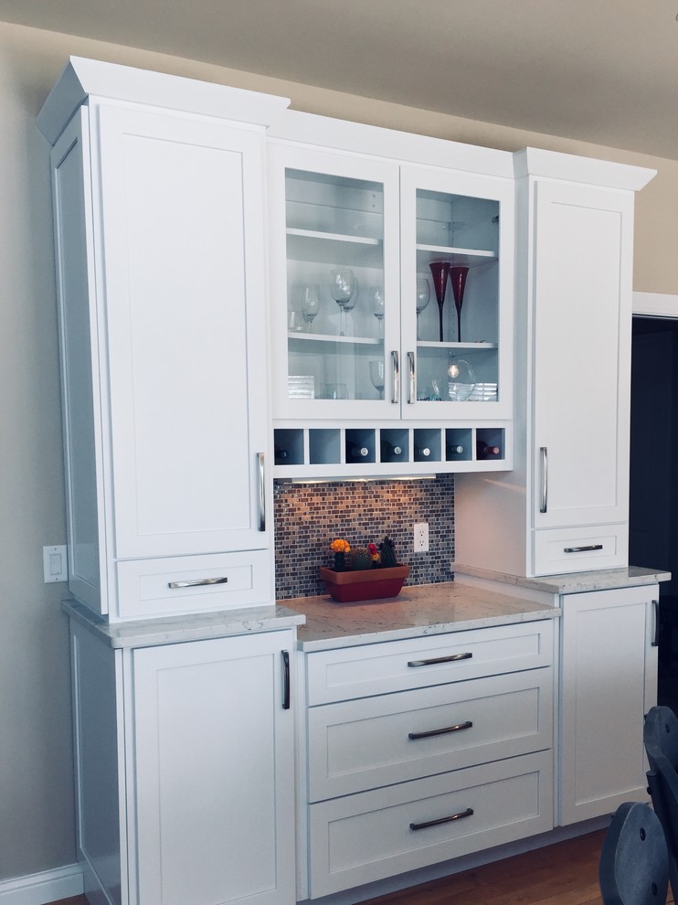 Mid-sized transitional medium tone wood floor kitchen photo with an undermount sink, shaker cabinets, white cabinets, quartz countertops, blue backsplash, glass tile backsplash, stainless steel appliances and an island
