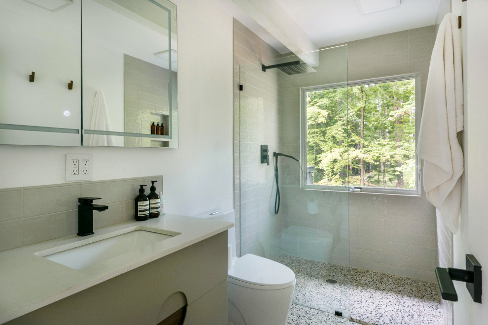 Design ideas for a small midcentury bathroom in New York with an open shower, a two-piece toilet, beige tile, ceramic tile, white walls, terrazzo floors, a drop-in sink, engineered quartz benchtops, beige floor, an open shower, beige benchtops, a freestanding vanity and exposed beam.