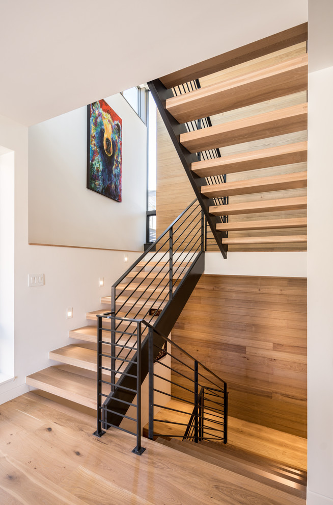 Mid-sized contemporary wood floating staircase in Denver with open risers and cable railing.