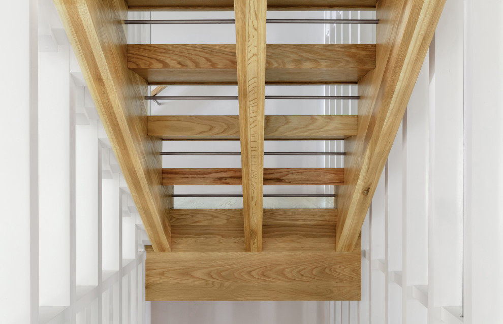 This is an example of a medium sized scandinavian wood l-shaped wood railing staircase in Indianapolis with open risers.