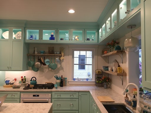Photo of a mid-sized contemporary l-shaped eat-in kitchen in Portland Maine with an undermount sink, shaker cabinets, blue cabinets, marble benchtops, white appliances, light hardwood floors, with island and beige floor.