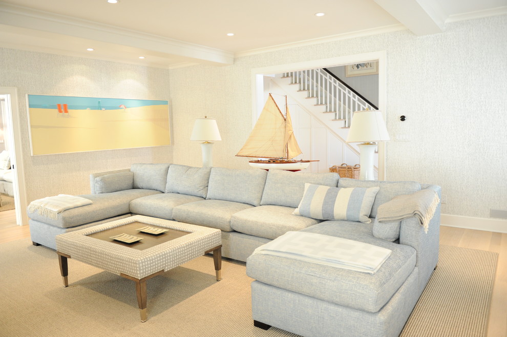 Mid-sized beach style formal enclosed living room in New York with blue walls, light hardwood floors, beige floor, a wall-mounted tv and no fireplace.