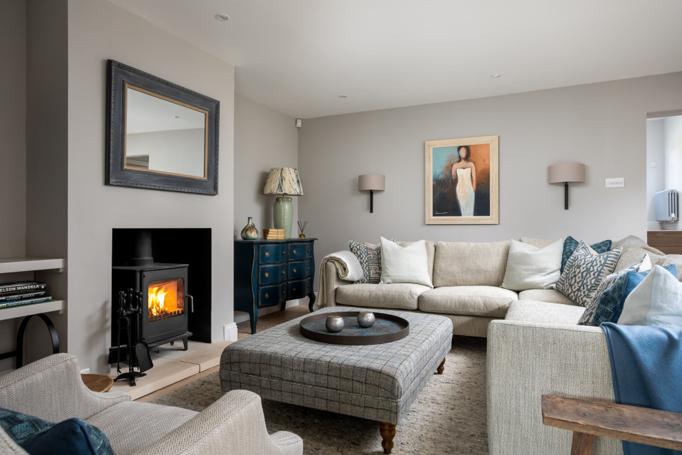 This is an example of a large beach style formal enclosed living room in Gloucestershire with grey walls and a wood stove.