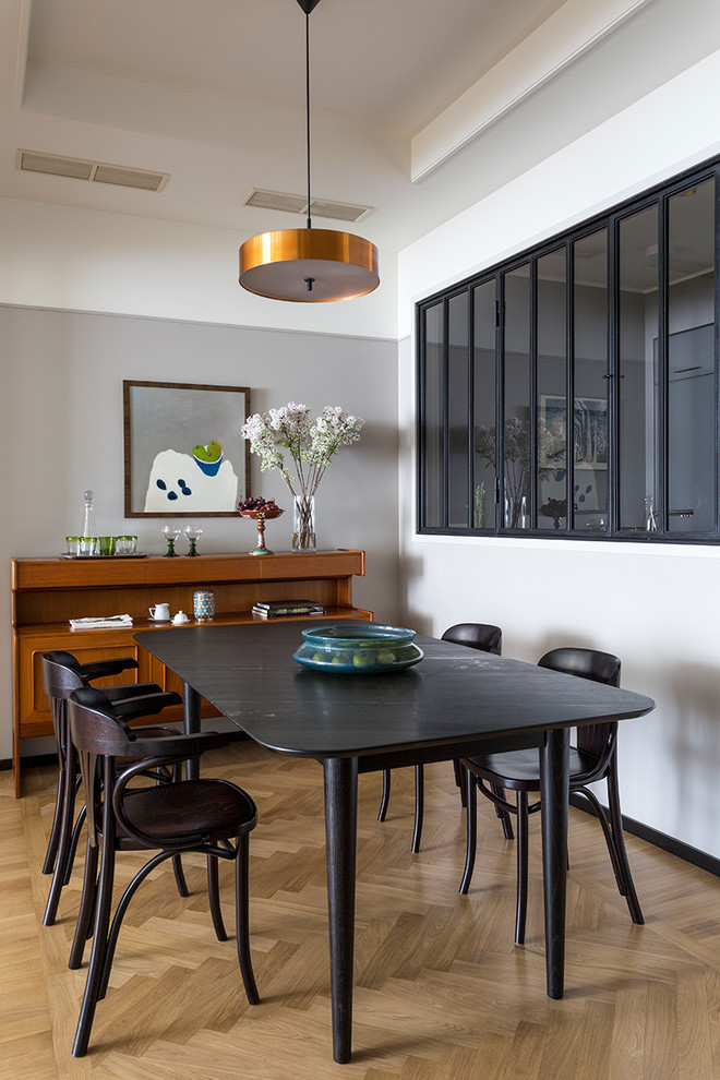 Ejemplo de comedor contemporáneo pequeño abierto con paredes grises y suelo de madera clara