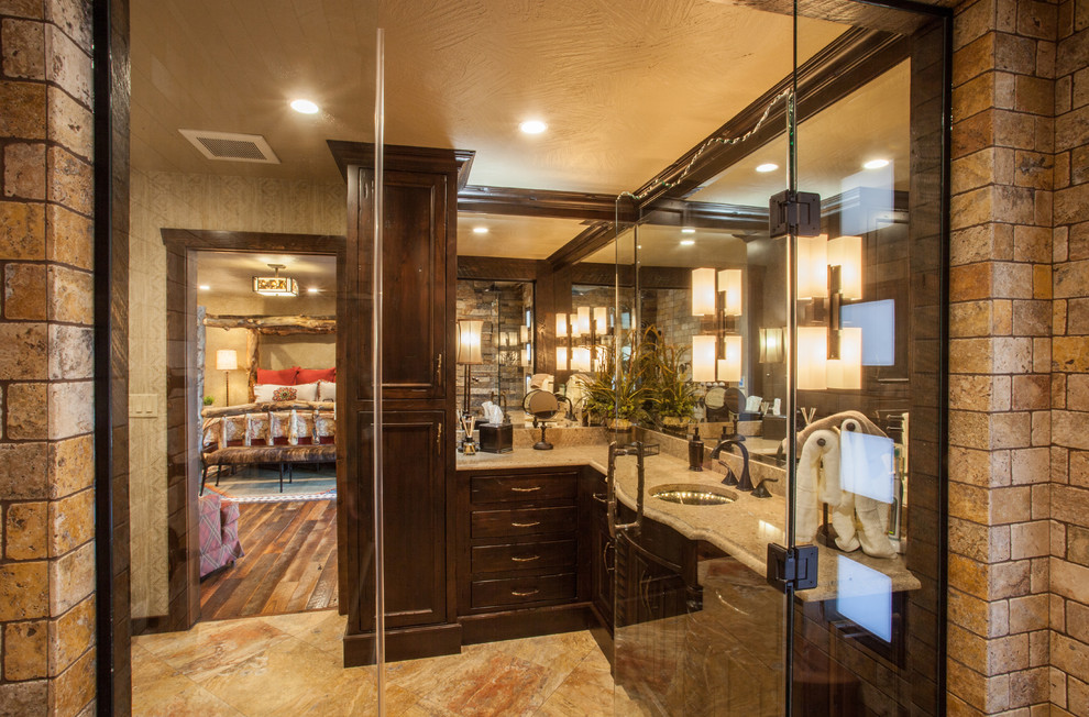 Inspiration for a mid-sized rustic master beige tile and stone tile travertine floor walk-in shower remodel with recessed-panel cabinets, dark wood cabinets, a two-piece toilet, beige walls, an undermount sink and quartz countertops