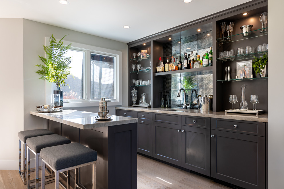 Photo of an expansive transitional wet bar in Los Angeles with an undermount sink, quartz benchtops and light hardwood floors.