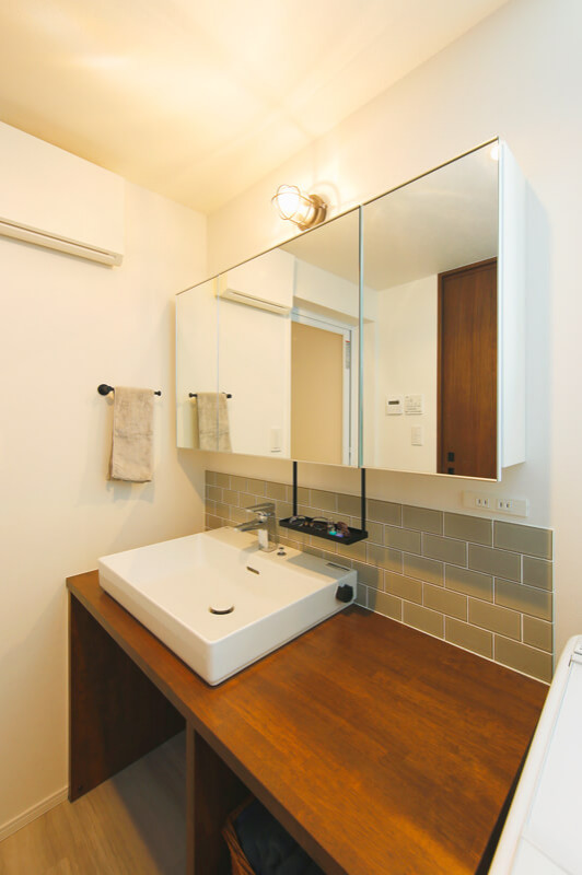 Inspiration for a small modern cloakroom in Tokyo Suburbs with medium wood cabinets, grey tiles, white walls, light hardwood flooring, a built-in sink, wooden worktops, beige floors, white worktops, feature lighting, a built in vanity unit, a wallpapered ceiling and wallpapered walls.