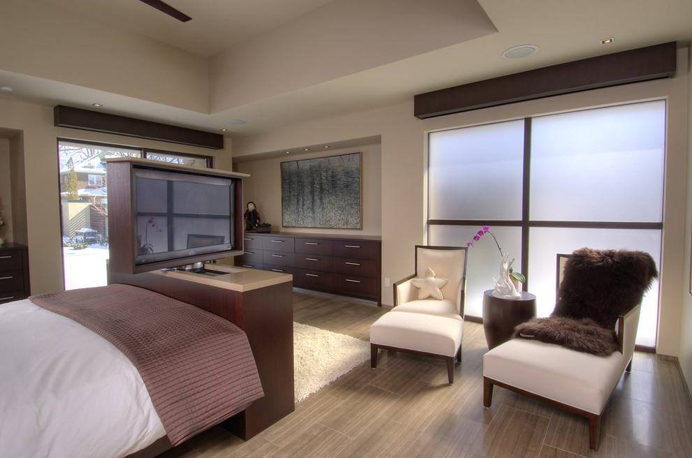 This is an example of a large contemporary master bedroom in Toronto with beige walls, porcelain floors and brown floor.