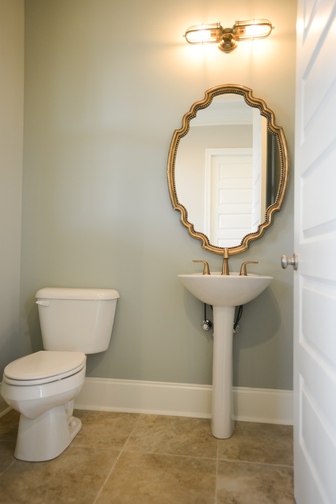 Mid-sized transitional powder room in New Orleans with a pedestal sink, a two-piece toilet, grey walls, ceramic floors and beige floor.