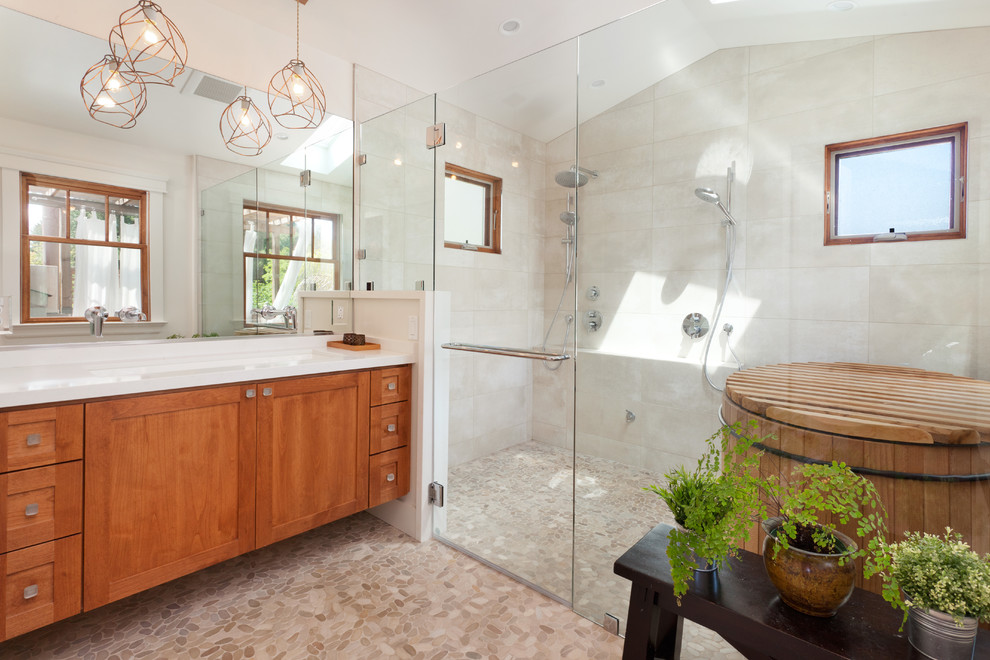 Inspiration for a mediterranean master bathroom in San Francisco with shaker cabinets, medium wood cabinets, a curbless shower, white walls, pebble tile floors, a trough sink, gray tile, a japanese tub, ceramic tile, quartzite benchtops, multi-coloured floor, white benchtops and a hinged shower door.