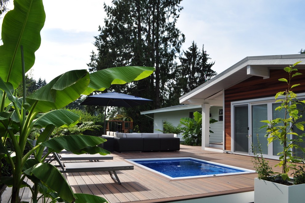 Tropical backyard rectangular pool in Vancouver with decking.
