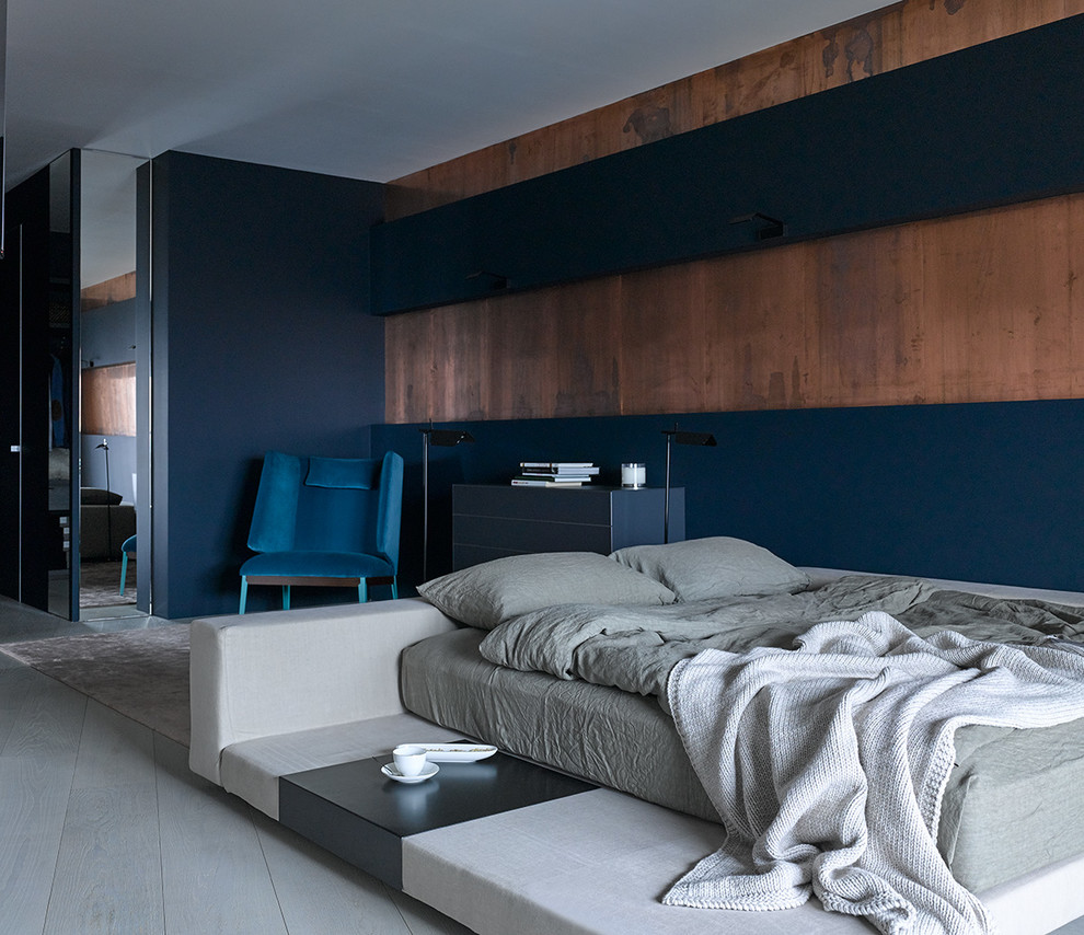 Contemporary master bedroom in Other with multi-coloured walls and light hardwood floors.