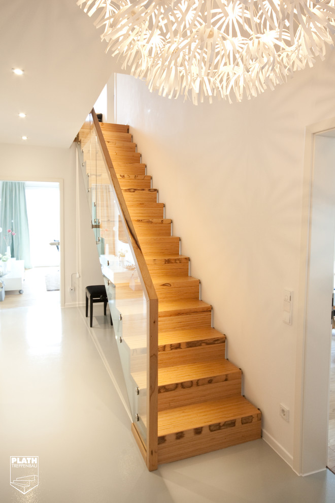This is an example of a contemporary wood straight staircase in Hamburg with wood risers.
