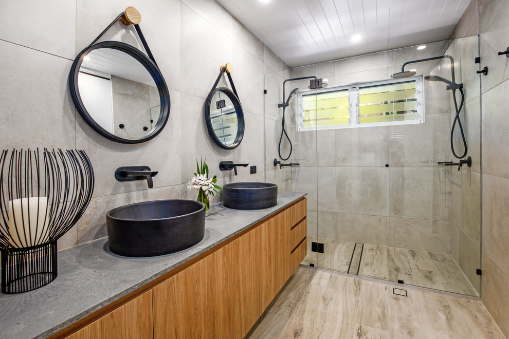 This is an example of a large contemporary bathroom in Sunshine Coast with medium wood cabinets, a double shower, porcelain tile, porcelain floors, a vessel sink, a hinged shower door, flat-panel cabinets, beige tile, beige floor and beige benchtops.
