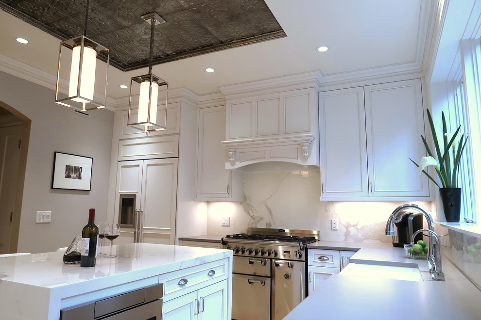 Example of a small transitional u-shaped light wood floor and brown floor enclosed kitchen design with a farmhouse sink, recessed-panel cabinets, white cabinets, quartz countertops, white backsplash, stone slab backsplash, stainless steel appliances, an island and white countertops