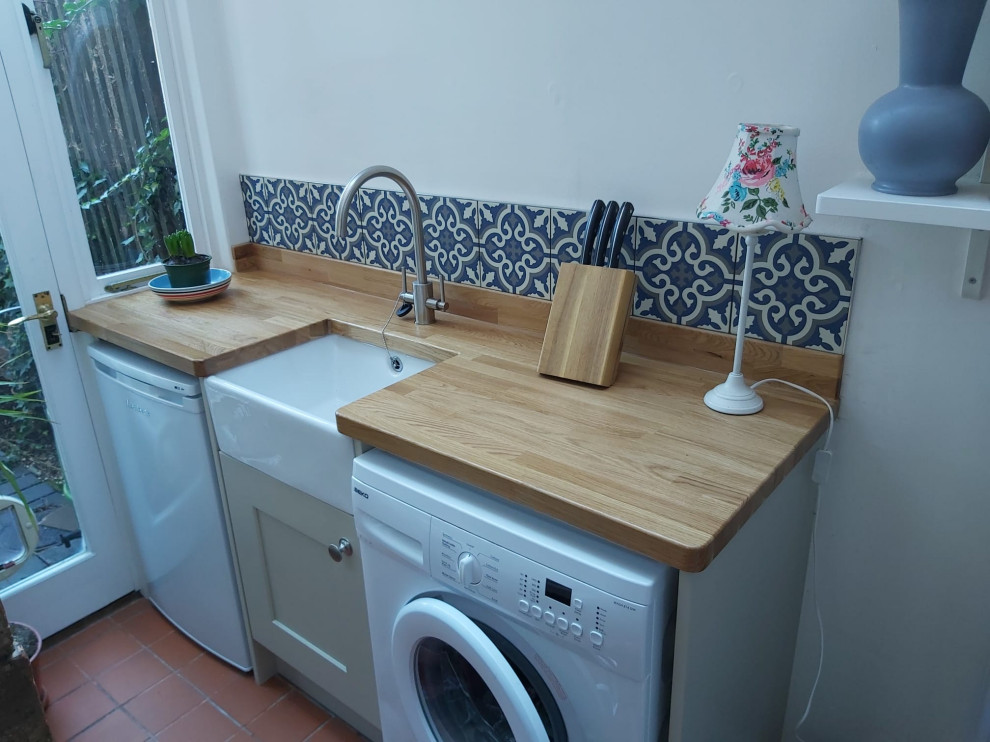 Foto de lavadero lineal clásico pequeño con fregadero sobremueble, encimera de madera y armarios estilo shaker