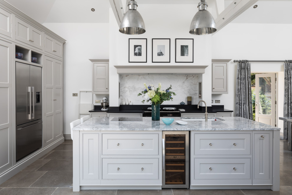 Classic u-shaped kitchen/diner in Kent with a submerged sink, recessed-panel cabinets, grey cabinets, marble worktops, multi-coloured splashback, marble splashback, stainless steel appliances, an island, grey floors, multicoloured worktops, exposed beams and a vaulted ceiling.