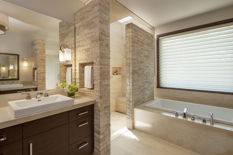This is an example of a contemporary master bathroom in Denver with a vessel sink, flat-panel cabinets, dark wood cabinets, marble benchtops, a corner shower, a one-piece toilet, travertine floors and a drop-in tub.