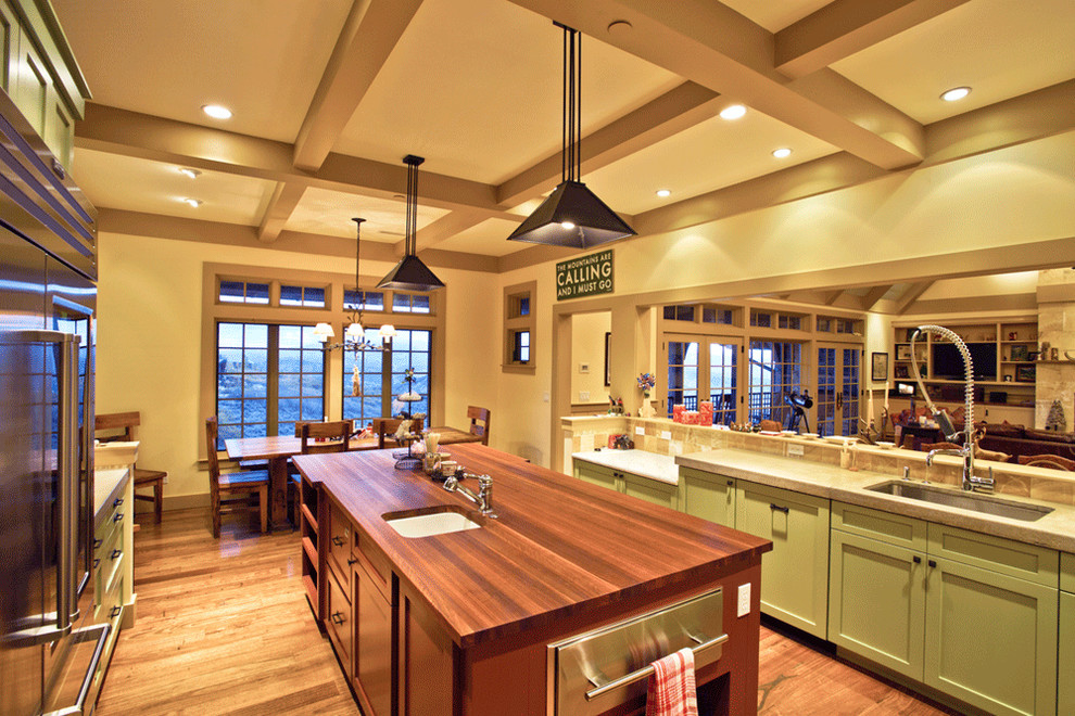 Large arts and crafts u-shaped eat-in kitchen in Salt Lake City with an undermount sink, recessed-panel cabinets, green cabinets, marble benchtops, brown splashback, stone tile splashback, stainless steel appliances, dark hardwood floors and with island.