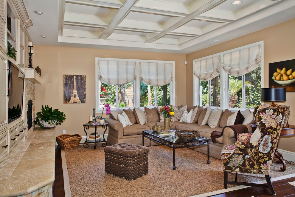 Inspiration for a traditional family room in San Diego with beige walls and a wall-mounted tv.