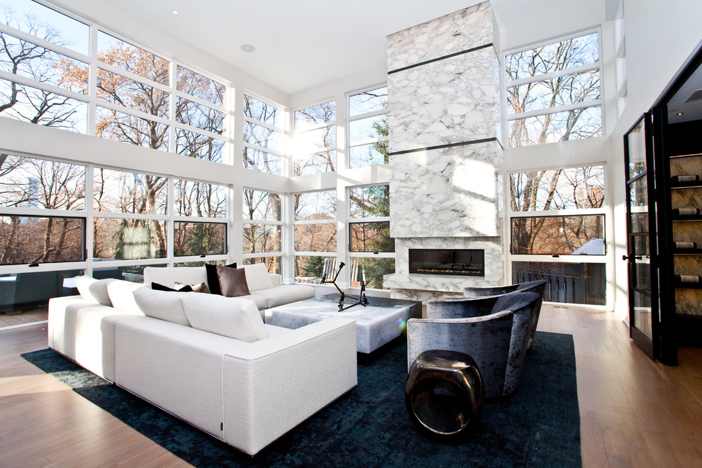 Photo of an expansive contemporary open concept living room in Toronto with white walls, a ribbon fireplace, light hardwood floors, a stone fireplace surround and no tv.