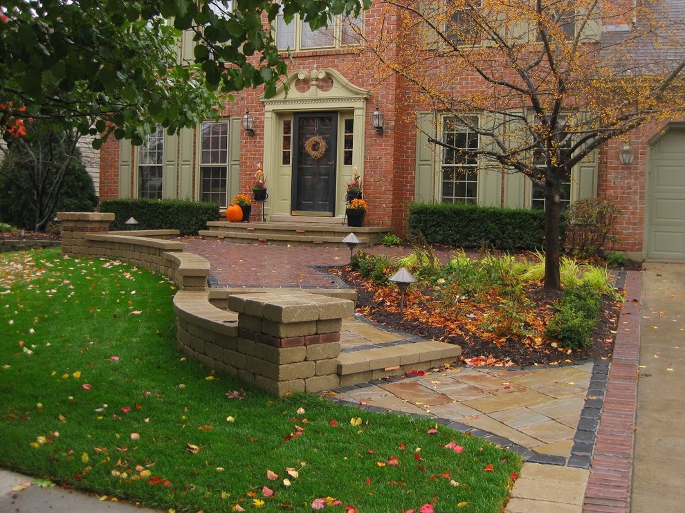 Photo of a mid-sized traditional front yard driveway in Chicago with a garden path and brick pavers.