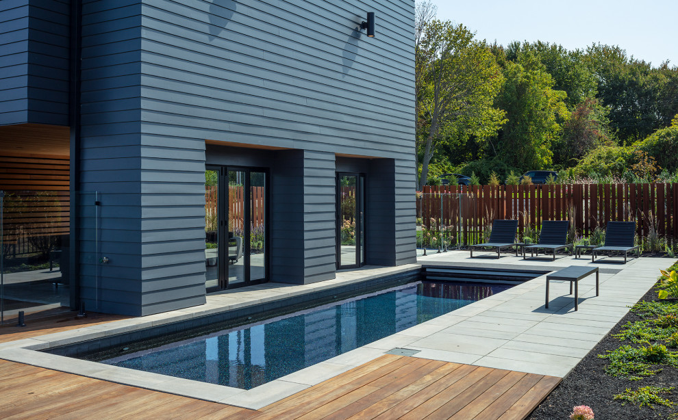Diseño de piscina natural actual de tamaño medio rectangular en patio lateral con entablado