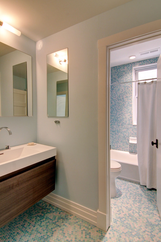 This is an example of a modern bathroom in DC Metro with mosaic tile and a shower curtain.