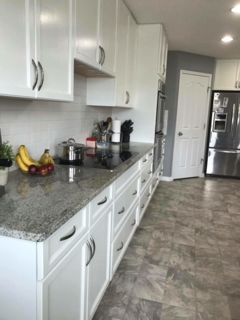 Inspiration for a mid-sized transitional u-shaped ceramic tile enclosed kitchen remodel in Edmonton with a drop-in sink, shaker cabinets, blue cabinets, quartzite countertops, gray backsplash, ceramic backsplash, stainless steel appliances and an island