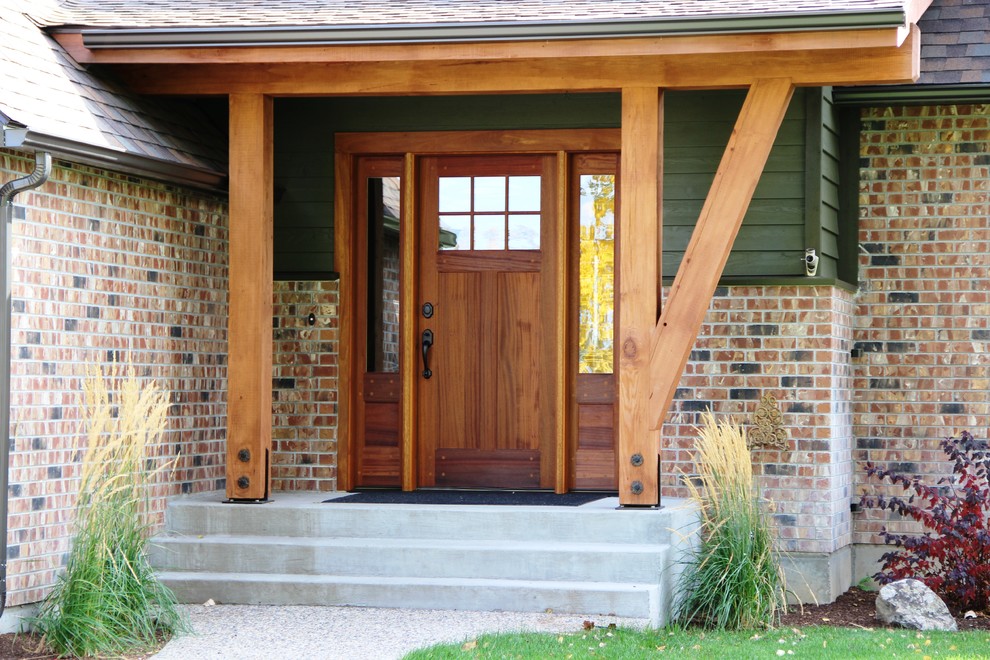 This is an example of a front door in Other with green walls, concrete floors, a single front door and a dark wood front door.