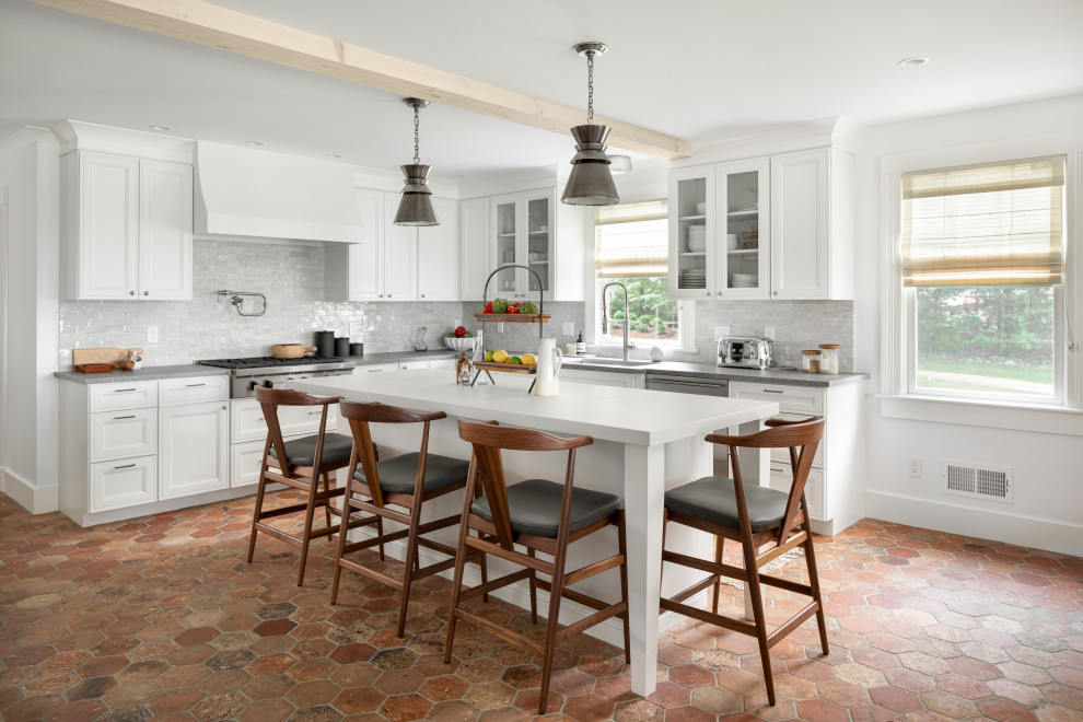 Design ideas for a beach style l-shaped kitchen in Providence with an undermount sink, recessed-panel cabinets, white cabinets, grey splashback, stainless steel appliances, with island, red floor and grey benchtop.