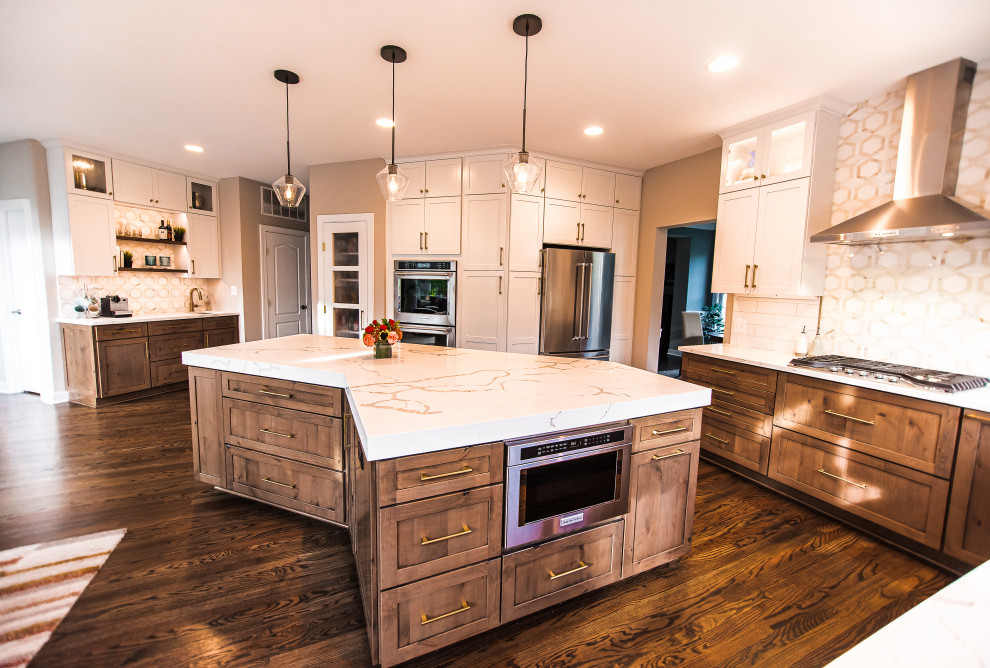 Inspiration for a mid-sized transitional l-shaped dark wood floor and brown floor eat-in kitchen remodel in Baltimore with a single-bowl sink, shaker cabinets, white cabinets, quartz countertops, white backsplash, marble backsplash, stainless steel appliances, an island and white countertops
