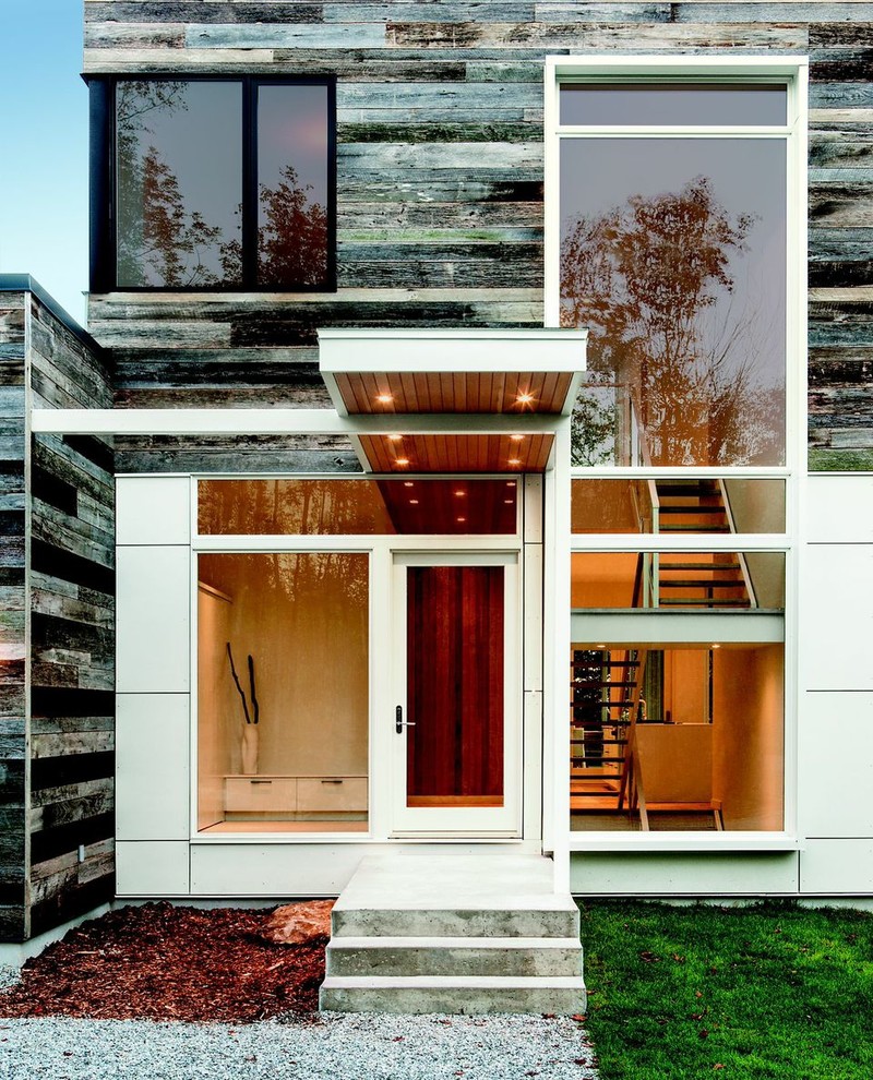 Inspiration for a large contemporary two-storey grey exterior in Raleigh with mixed siding and a flat roof.