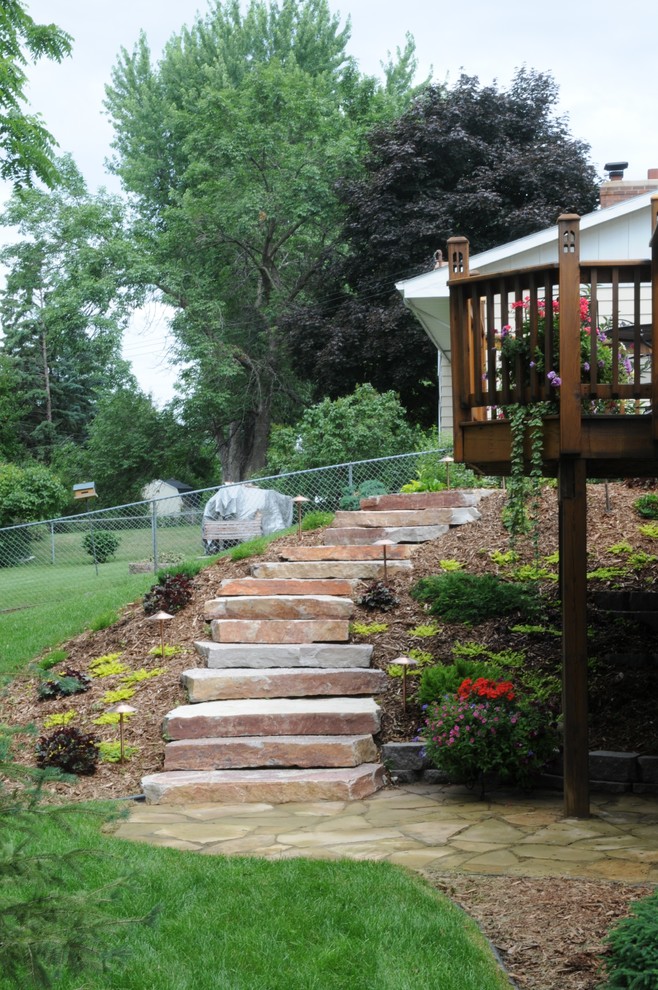 Photo of a small traditional sloped partial sun garden in Minneapolis with natural stone pavers.