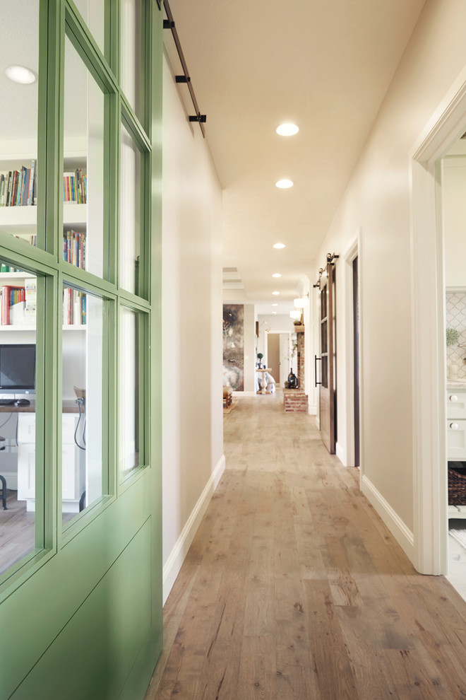Example of a mid-sized mountain style light wood floor hallway design with white walls