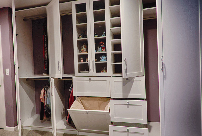 This is an example of a mid-sized contemporary women's built-in wardrobe in Philadelphia with recessed-panel cabinets, white cabinets, carpet and beige floor.