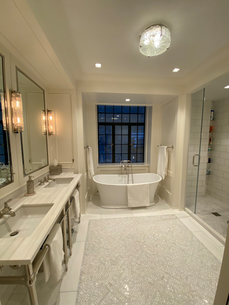 This is an example of a large contemporary bathroom in New York with open cabinets, a japanese bath, a one-piece toilet, beige tiles, marble tiles, white walls, mosaic tile flooring, a submerged sink, marble worktops, white floors, a hinged door, white worktops, double sinks, a floating vanity unit, a drop ceiling and panelled walls.