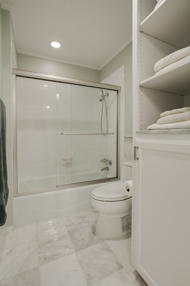 Inspiration for a mid-sized contemporary master bathroom in Dallas with an undermount sink, shaker cabinets, white cabinets, onyx benchtops, a shower/bathtub combo, white tile, stone tile, green walls and marble floors.