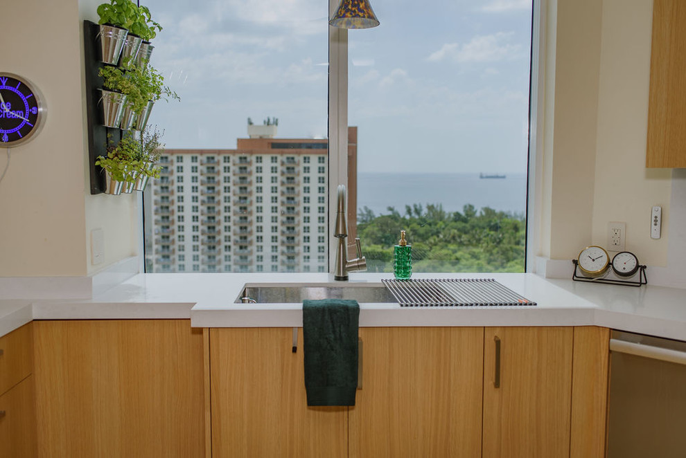 Open concept kitchen - mid-sized transitional u-shaped porcelain tile open concept kitchen idea in Miami with an undermount sink, flat-panel cabinets, light wood cabinets, quartz countertops, white backsplash, stainless steel appliances, an island and white countertops